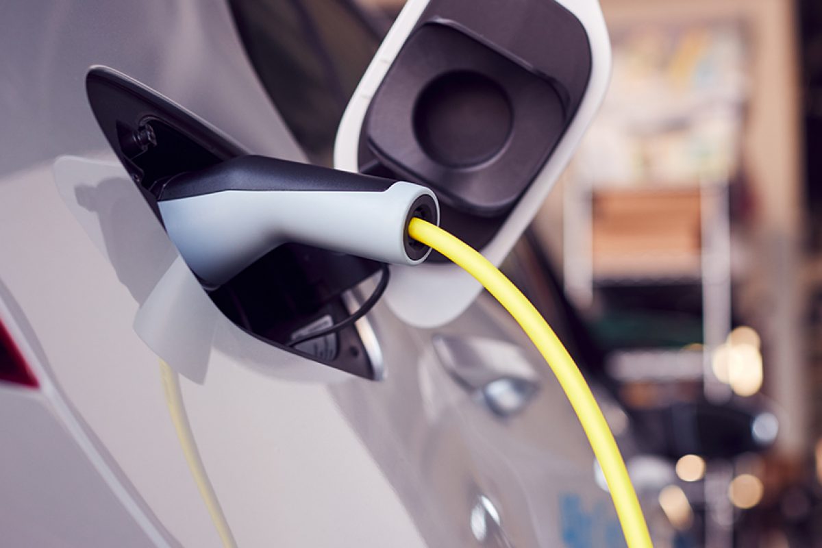 Close Up Of Power Cable Charging Environmentally Friendly Zero Emission Electric Car In Garage